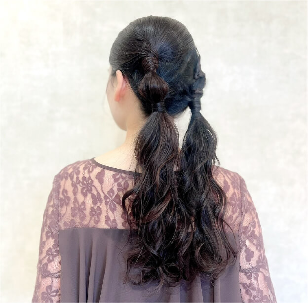 やわらかいカールを生かしたローポニーテールアレンジ。結び目をアクセントにした大人可愛いヘアスタイル。