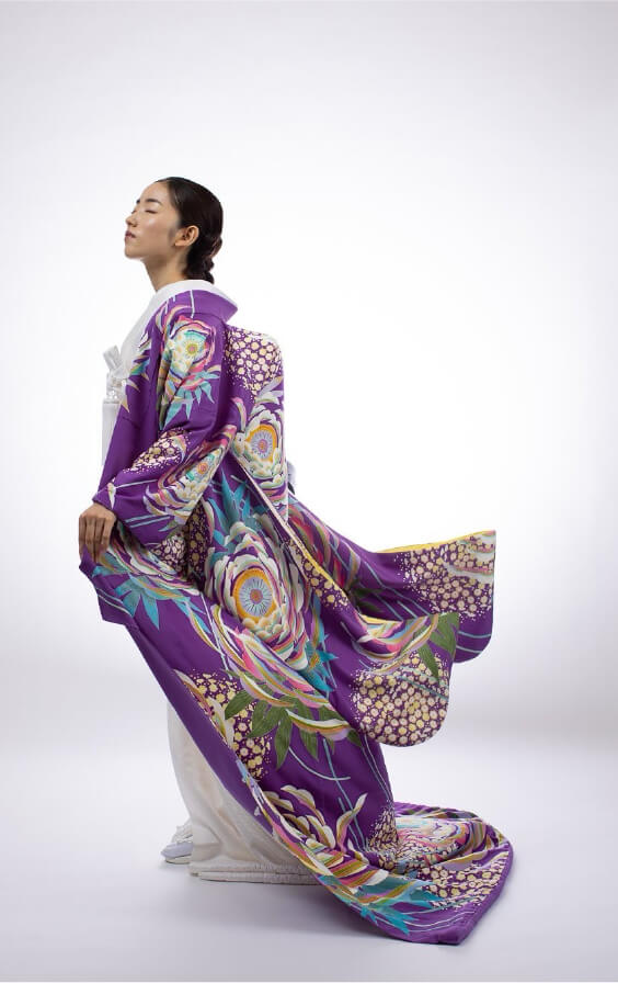 紫の打掛をまとい、上品に立つ女性の横姿