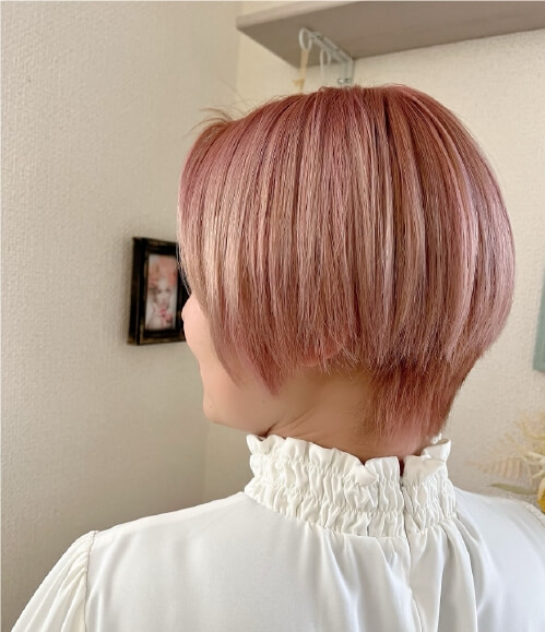 ピンクベージュのショートボブヘア。滑らかな質感と自然な丸みをもつ後ろ姿